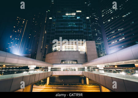 Les gratte-ciel modernes et de passerelles dans la nuit, au niveau central, à Hong Kong, Hong Kong. Banque D'Images