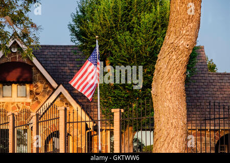 Une maison à Oklahoma City, Oklahoma, USA, vole le drapeau américain sur un mât. Lumière du soir. Banque D'Images