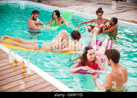 Heureux les jeunes couples swimming in pool et s'amuser Banque D'Images