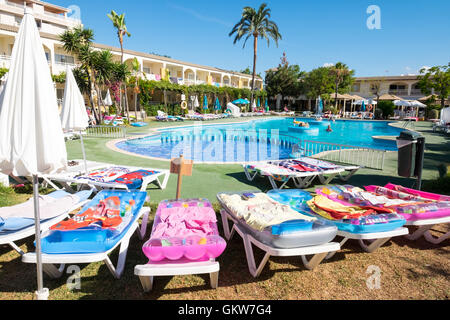 , À gauche sur les chaises longues autour de la piscine dans la matinée par les touristes de réserver des chaises longues pour plus tard dans la journée, Majorque Banque D'Images