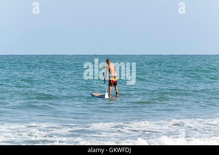 Le Stand Up Paddle Surf. Surfer sur sa planche de surf, dans la plage de Castellon de la Plana (Espagne) Banque D'Images