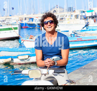 Jeune homme italien sur Vespa Scooter Smiling Banque D'Images