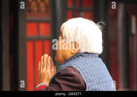Une femme prie au monastère de Wenshu à Chengdu en Chine. Banque D'Images