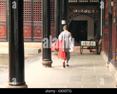 Un moine se promène le long de cour en monastère de Wenshu à Chengdu en Chine. Banque D'Images