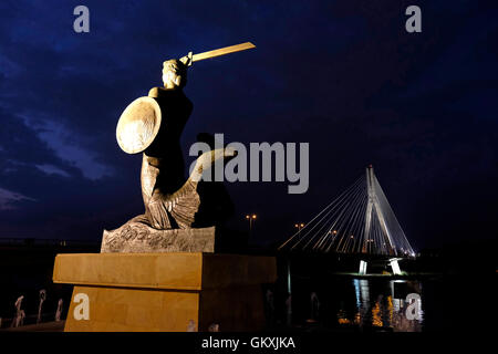 Vue de la statue en bronze de Varsovie Mermaid Syrenka Warszawska un symbole de Varsovie, représenté sur les armoiries de la ville faite par Louise sculptrice Nitschowa en 1939 à l'emplacement du pont Swietokrzyski traverse la Vistule à Varsovie, Pologne Banque D'Images