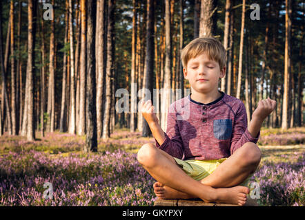 Petit garçon de méditer dans la forêt. Banque D'Images