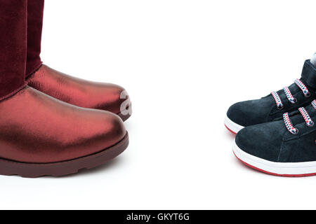 Chaussures noires pour les fils et les rouges pour maman sur le blanc comme concept de la filiation Banque D'Images