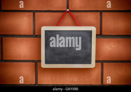 Tableau blanc accroché à un brickwall. Close up. Banque D'Images