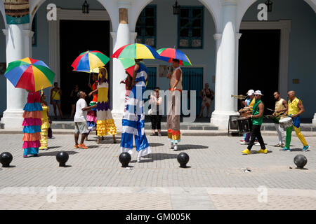 Un groupe de musiciens de carnaval sur pilotis vêtus de costumes divertissent les touristes sur la Plaza de Vieja à la Habana Cuba Banque D'Images