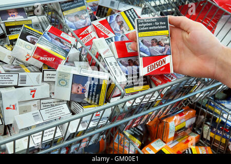 Des cigarettes dans un supermarché Aldi avec photos sur les paquets de cigarettes pour illustrer les dangers du tabagisme Banque D'Images