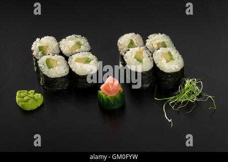 Rouleaux de sushi hosomaki avec avocat décoré de salade d'algues et wasabi Banque D'Images