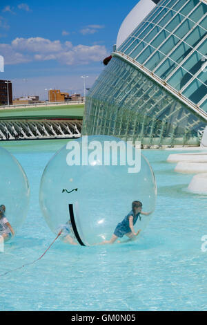 Les enfants à l'intérieur d'une boule à la marche de l'eau science park en face de l'Hemisferic bâtiment iMax à Valence Banque D'Images