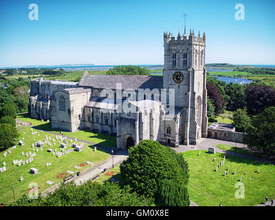 Vue aérienne de Christchurch Priory à Christchurch, Dorset, Angleterre. Les aiguilles pointe sur l'île de Wight dans la distance. Banque D'Images