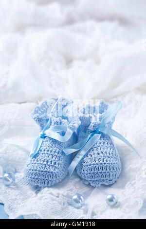 Chaussures bébé bleu sur un tissu blanc Banque D'Images