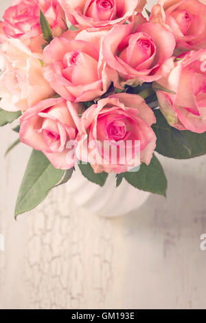 Roses roses dans un vase blanc Banque D'Images