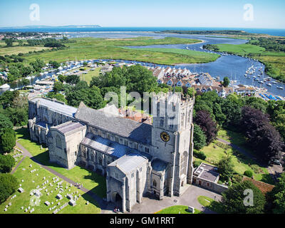 Vue aérienne de Christchurch Priory à Christchurch, Dorset, Angleterre. Les aiguilles pointe sur l'île de Wight dans la distance. Banque D'Images