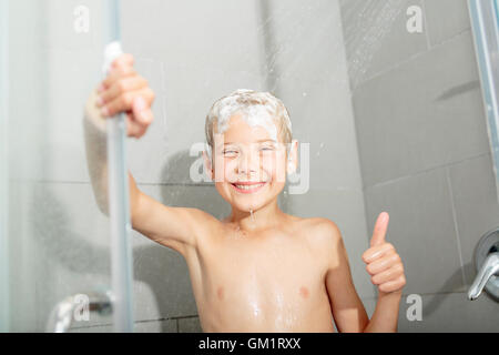 Happy teen boy lave-tête de douche dans la salle de bains Banque D'Images