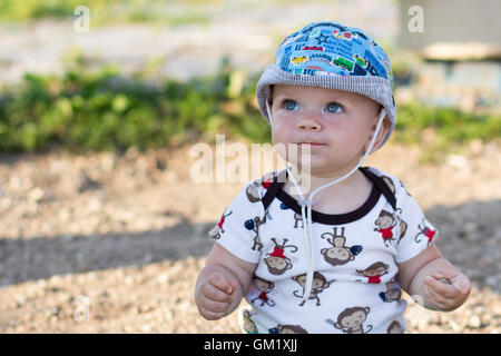 Mignon Bébé Garçon jouant et riant dans le parc. L'été est beaucoup de verdure autour d'une des choses intéressantes pour les miettes. Enfant 1 ans Banque D'Images