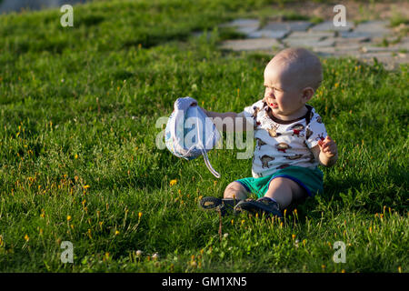 Mignon Bébé Garçon jouant et riant dans le parc. L'été est beaucoup de verdure autour d'une des choses intéressantes pour les miettes. Enfant 1 ans Banque D'Images