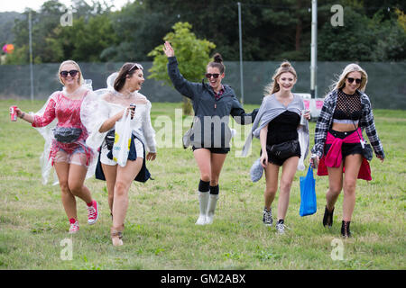 Les fans de musique en arrivant à la V Festival à Hylands Park, Chelmsford, Essex,sous la pluie. Banque D'Images