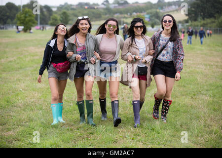 Les fans de musique en arrivant à la V Festival à Hylands Park, Chelmsford, Essex,sous la pluie. Banque D'Images