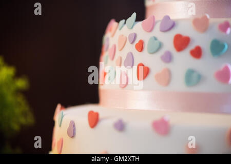 Close up love heart détails sur un gâteau de mariage au cours d'une réception de mariage Banque D'Images