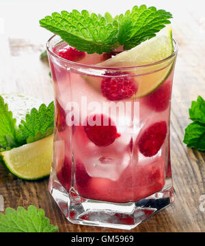 Boisson d'été avec des framboises, de la chaux et de la glace sur une table en bois. Selective focus Banque D'Images