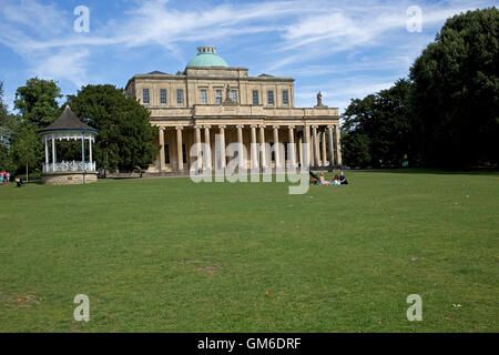 Famille picnicing sur la pelouse en face de Pittville pumproom le plus grand bâtiment classé grade 1 spa distribution historiquement g santé Banque D'Images