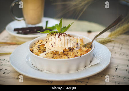Vanille de fusion boule de crème glacée avec une menthe quitter en haut d'une sueur et tarte aux pommes croquantes. Banque D'Images