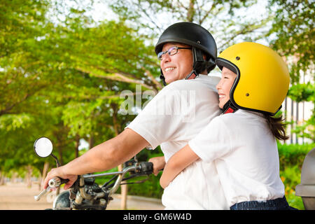 Père et fille voyageant sur la moto Banque D'Images