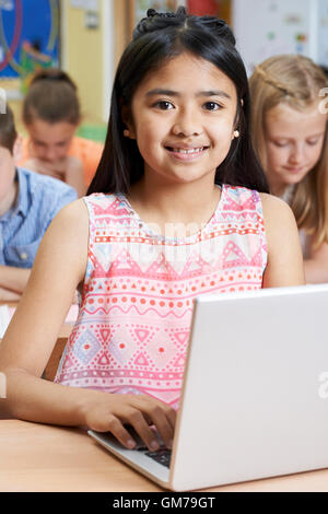 Élève de l'élémentaire femelle Using Laptop in Computer Class Banque D'Images