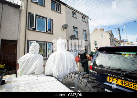 Les officiers de l'armée et PSNI agents techniques de recherche sur l'ancienne route Glenarm dans Larne, Co Antrim. Une Marine Royale est remise en question par des détectives enquête sur le terrorisme lié à l'Irlande du Nord, c'est connecté à deux grands bras républicain dissident trouve. Banque D'Images