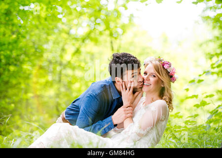 Beau couple de mariés à l'extérieur en vert forêt. Banque D'Images