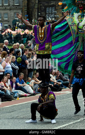 Les noires sont des acrobates et un homme portant un costume 'character' participant à la Cavalcade, une partie de l'Edinburgh Festival de Jazz. Banque D'Images