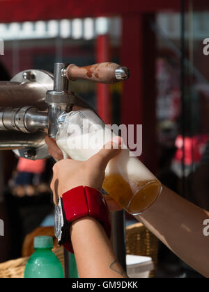 Serveuse part verser une pinte de bière à la pression Banque D'Images