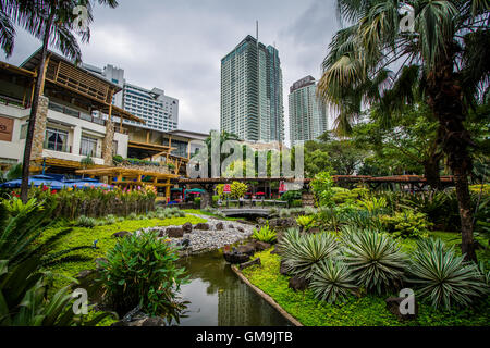 Jardins et de gratte-ciel au parc de Greenbelt, dans Ayala, Makati, Metro Manila, Philippines. Banque D'Images