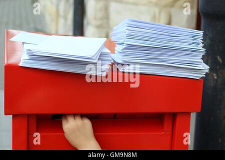 La main de l'enfant mettre des lettres dans la boîte aux lettres Banque D'Images