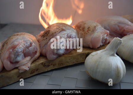 Cuisses de poulet avec l'ail sur feu Banque D'Images
