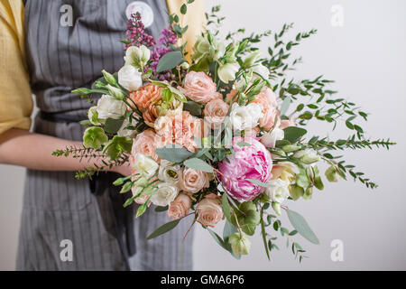 Riche bouquet de pivoines rose et blanc fleurs roses eustomia, vert feuille vase en verre. Bouquet frais du printemps. Arrière-plan de l'été. Banque D'Images