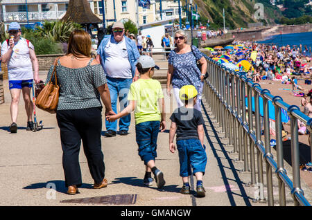 Une mère et son fils à pied le long de la promenade le long de la plage à Teignmouth dans le Devon, Royaume-Uni. Banque D'Images