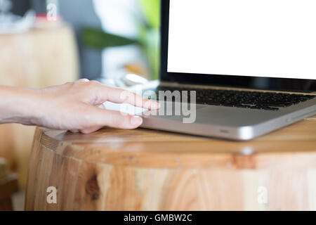 La main de femme sur l'ordinateur portable ordinateur portable sur un bureau en bois Banque D'Images