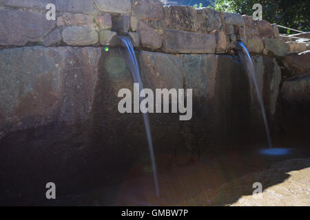 L'eau qui coule à Ollantaytambo thru petit satellite construit en pierres locales Banque D'Images