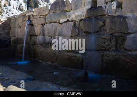 L'eau qui coule à Ollantaytambo thru petit satellite construit en pierres locales Banque D'Images