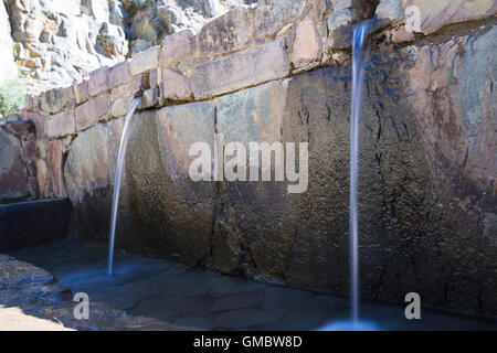 L'eau qui coule à Ollantaytambo thru petit satellite construit en pierres locales Banque D'Images