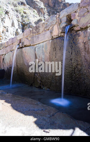 L'eau qui coule à Ollantaytambo thru petit satellite construit en pierres locales Banque D'Images