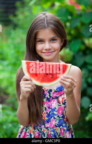 Portrait d'une jeune brunette petite fille avec le melon d'eau, piscine d'été Banque D'Images