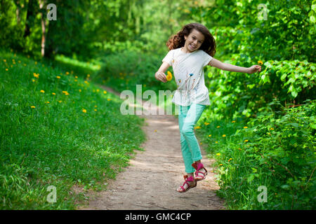 Happy little girl running in summer park Banque D'Images