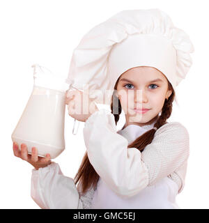 La cuisine et les gens concept - petite fille dans un tablier blanc tenant une cruche de lait, isolé sur fond blanc Banque D'Images