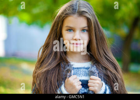 Portrait d'une belle petite fille de neuf ans dans la région de autumn park Banque D'Images