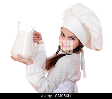 La cuisine et les gens concept - petite fille dans un tablier blanc tenant une cruche de lait, isolé sur fond blanc Banque D'Images